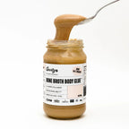 Jar of Bone Broth Body Glue - Natural - 390g by Gevity Rx with spoon lifting thick broth against white background