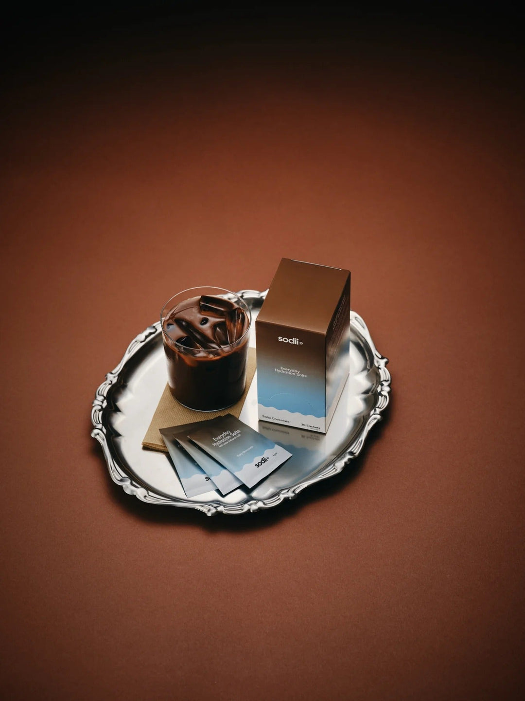 Salty Chocolate - 30 Sachets by Sodii shown with a glass of iced chocolate drink on an ornate silver tray, highlighting keto-friendly, low carb appeal.