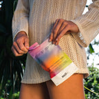 Person holding Salty Variety Pack - 8 Sachets by Sodii, featuring colorful hydration salts pouch with nature background.