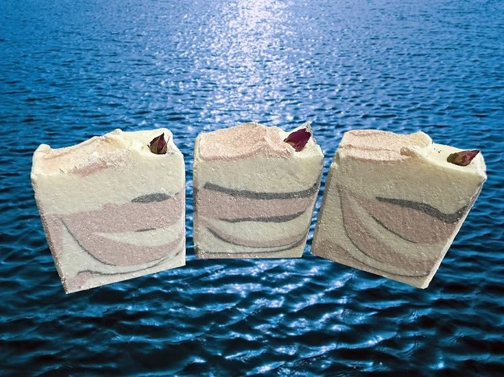 Three bars of Tidal Blush Salt Bar Tallow Soap - 160g with natural swirls by The Bubble Jungle floating on water surface.