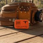 Tradie Tallow Balm - 40ml by Bare Bones Beauty displayed on a workbench with a leather tool belt in background