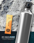 Zesty Orange Electrolyte Drink Mix - 30 Sticks by SALTT next to aluminum water bottle on textured background